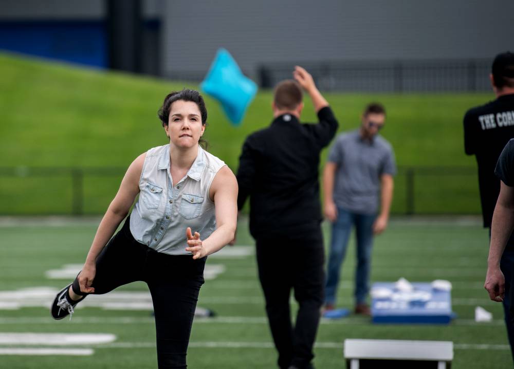 Women throwing a cornhole bag with sheer determination on her face